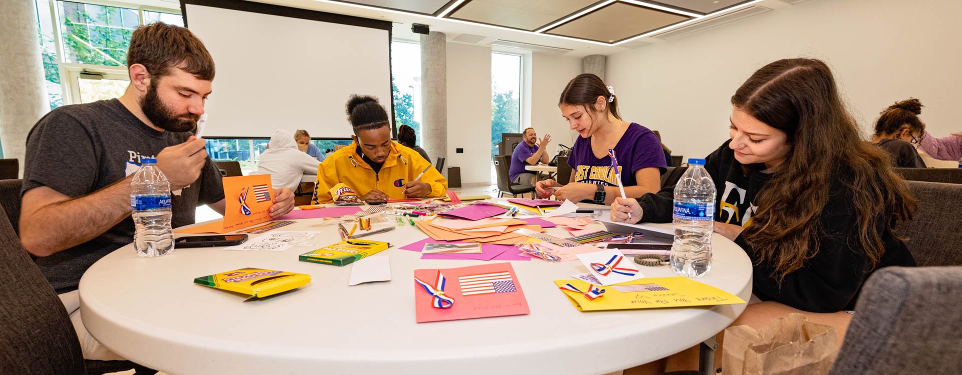 Students make material for troops overseas. Students were working with Packs4Patriots during the 9/11 Day of Service in the MCSC. (ECU Photo by Cliff Hollis)